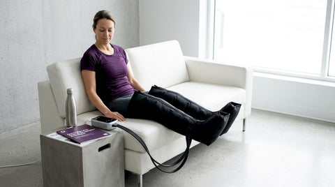 Un homme se détend dans son salon tout en profitant des bienfaits de ses bottes de compression.